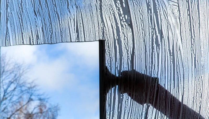 Squeegee clearing soapy water from a window